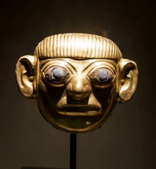 cabeça de personagem de ouro, com olhos de prata e pedras de lápis-lazúlis, de 12,50 cm. de altura.