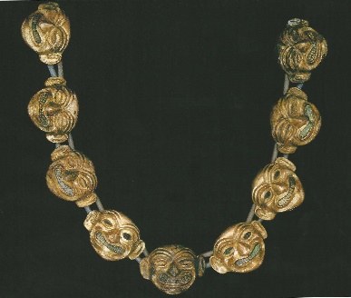 Colar de ouro de cabeças humanas sorridentes, simbolizando a vida e a morte, cada peça de 5,80 cm.